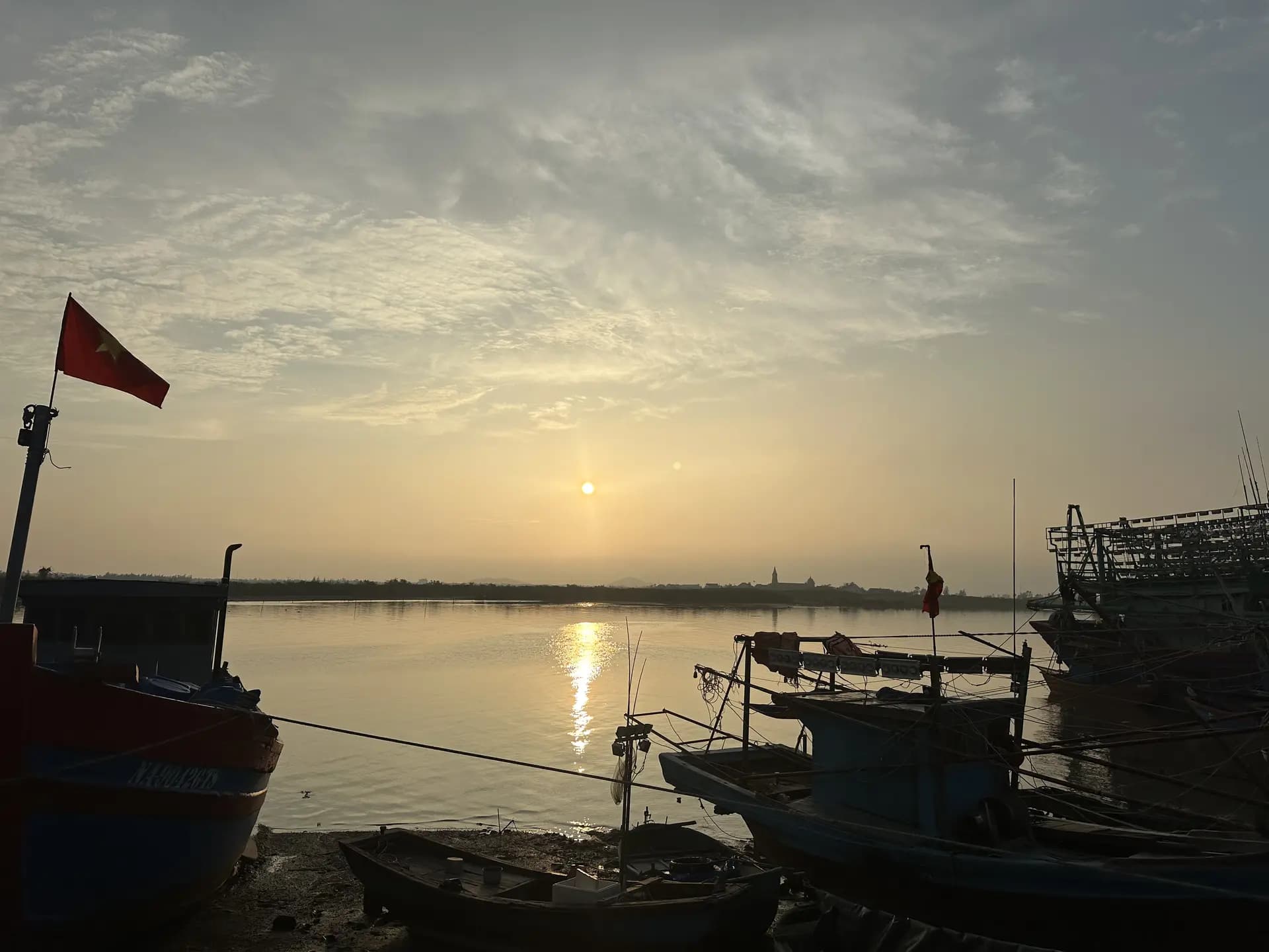 Thuyền cá và mặt nước phẳng lặng ở chợ cá Tiến Thủy buổi sớm